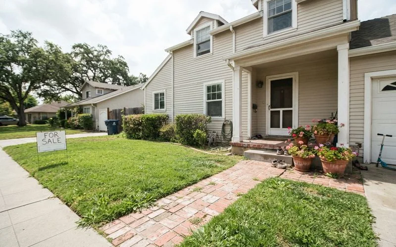 A tidy Austin front yard with freshly mulched beds, a trimmed lawn, and a clear walkway leading to the front door, staged for a home sale